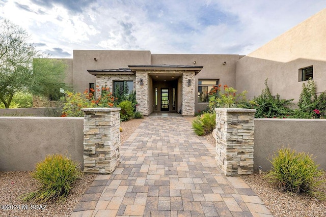 entrance to property with stone siding and stucco siding