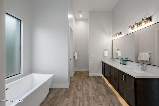 bathroom featuring a tub, hardwood / wood-style floors, and vanity