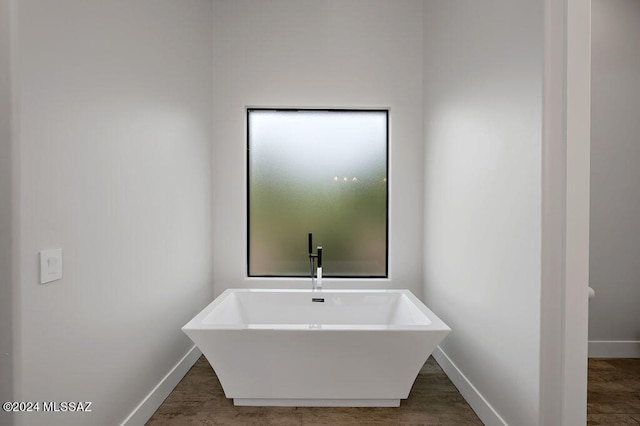 bathroom featuring hardwood / wood-style floors and a washtub