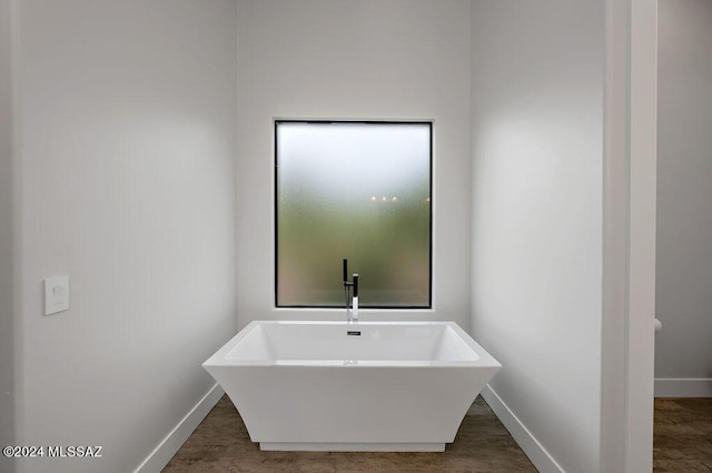 bathroom featuring baseboards and a soaking tub