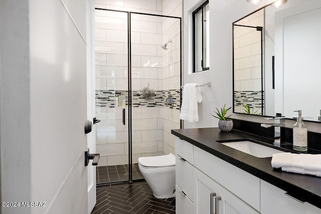 bathroom with a shower with door, vanity, and toilet