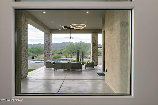 interior space with a mountain view and ceiling fan