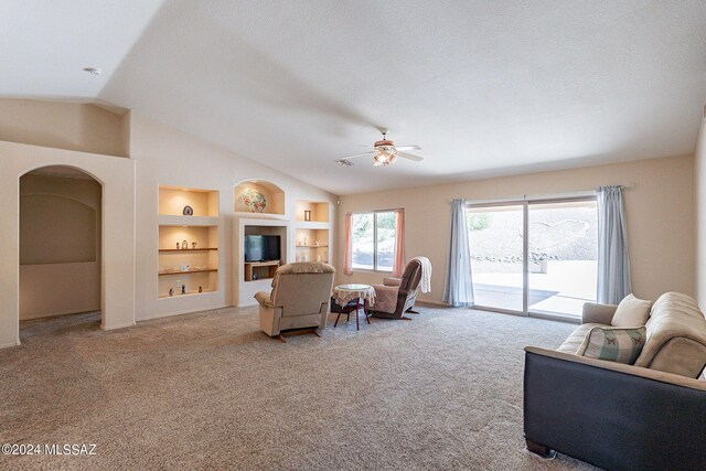 living room featuring built in shelves, a textured ceiling, ceiling fan, vaulted ceiling, and carpet floors