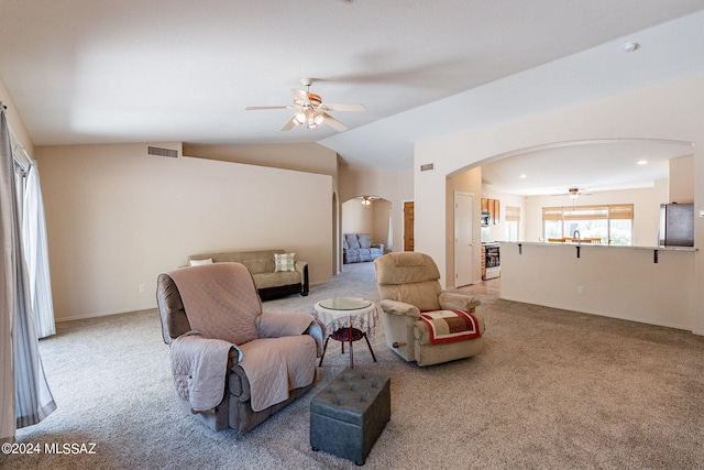 living room featuring vaulted ceiling, carpet flooring, visible vents, arched walkways, and ceiling fan