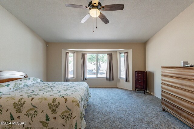 bedroom with a textured ceiling, carpet, and ceiling fan