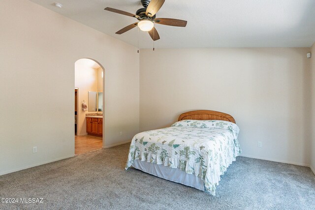 bedroom featuring lofted ceiling, light colored carpet, ceiling fan, and ensuite bathroom