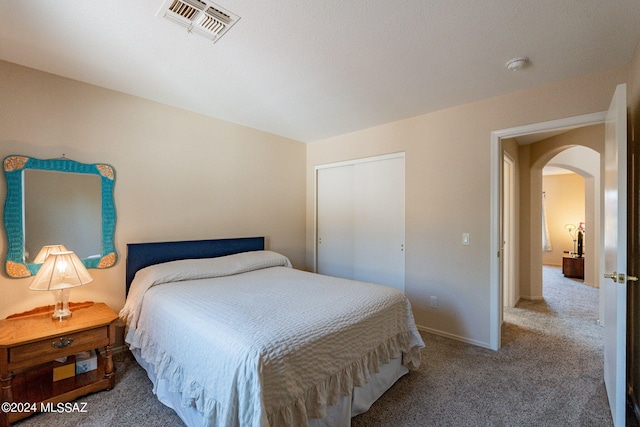bedroom featuring carpet flooring, arched walkways, baseboards, and visible vents