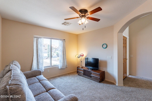 living area with carpet flooring, baseboards, arched walkways, visible vents, and a ceiling fan