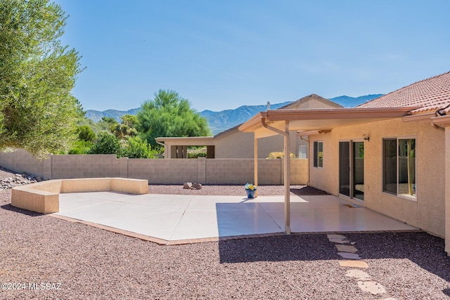 view of patio featuring a mountain view and a fenced backyard