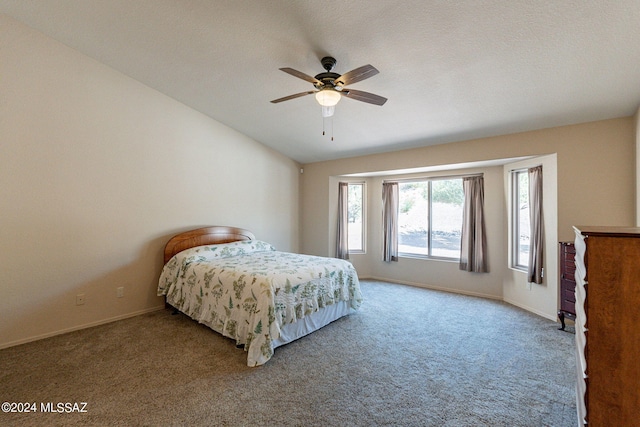 carpeted bedroom with ceiling fan, vaulted ceiling, and a textured ceiling