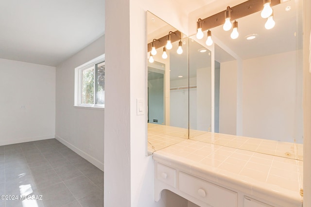 bathroom with baseboards and tile patterned floors