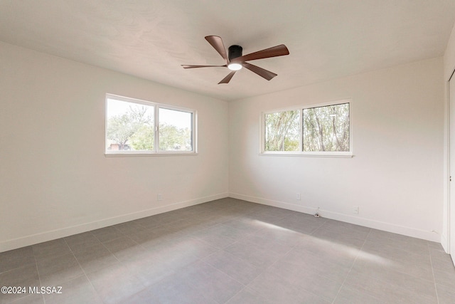 empty room featuring ceiling fan and baseboards