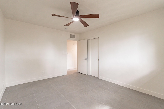 unfurnished bedroom with a ceiling fan, baseboards, visible vents, and a closet