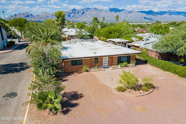 view of front of home with driveway, brick siding, and a mountain view