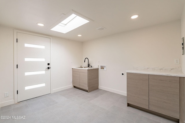 washroom featuring hookup for a washing machine, cabinet space, a sink, electric dryer hookup, and baseboards