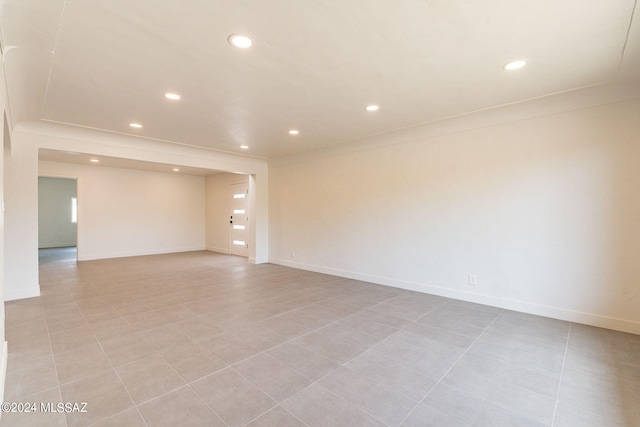 spare room featuring baseboards, crown molding, and recessed lighting