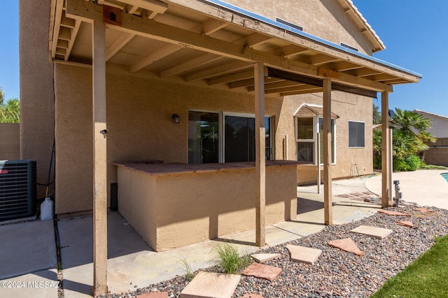 rear view of property with a patio, fence, stucco siding, and central air condition unit