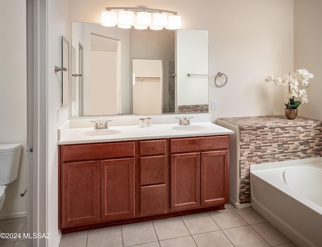 full bathroom featuring a garden tub, a sink, toilet, and tile patterned floors