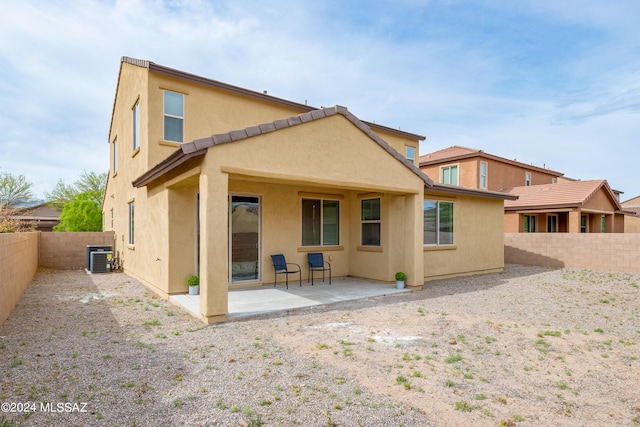 rear view of house with a fenced backyard, a patio, and stucco siding