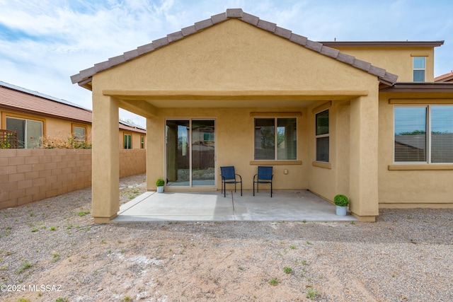 back of house with stucco siding, fence, and a patio