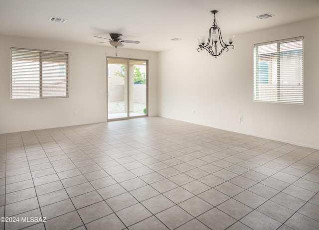 empty room featuring visible vents, baseboards, and ceiling fan with notable chandelier