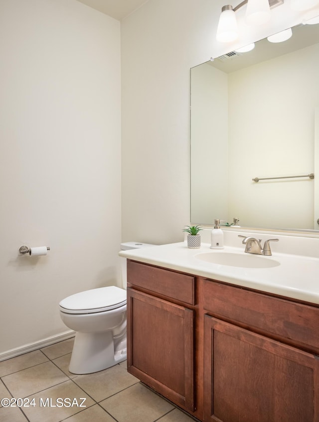 half bath with vanity, toilet, and tile patterned floors