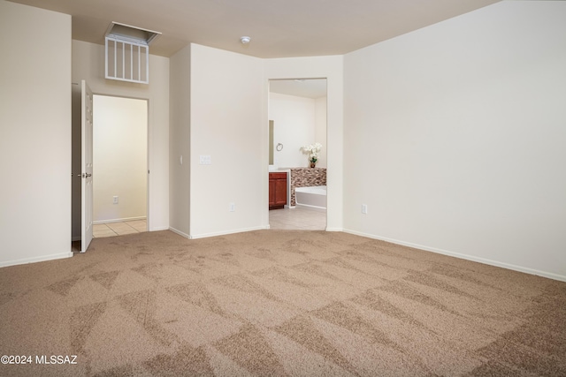 unfurnished bedroom with carpet, connected bathroom, and baseboards