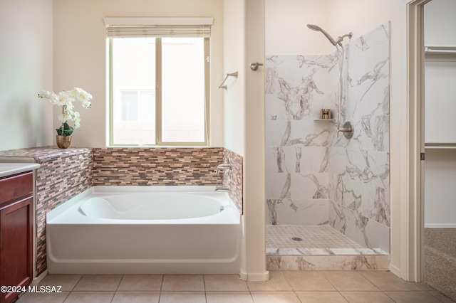 bathroom featuring a bath, tile patterned flooring, and tiled shower