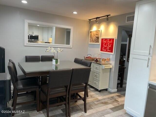 dining space featuring light hardwood / wood-style floors and track lighting