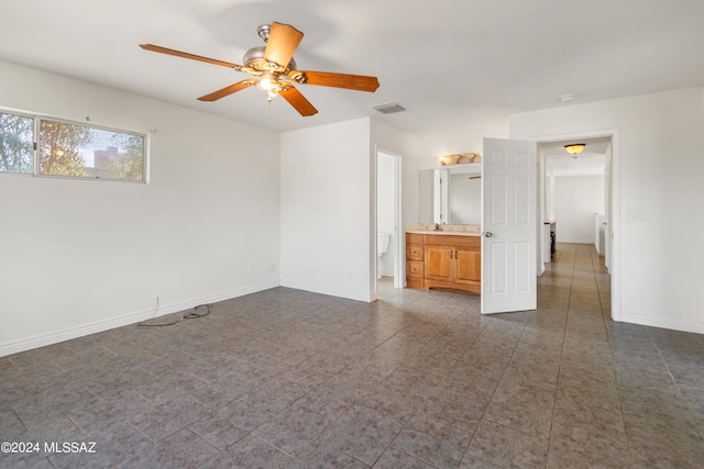 unfurnished bedroom with ceiling fan and connected bathroom