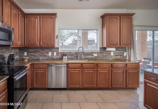 kitchen featuring appliances with stainless steel finishes, backsplash, a wealth of natural light, and sink