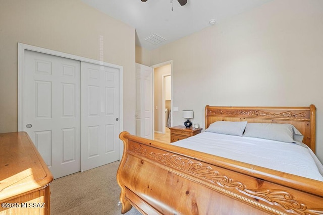 bedroom featuring a ceiling fan, visible vents, light carpet, and a closet
