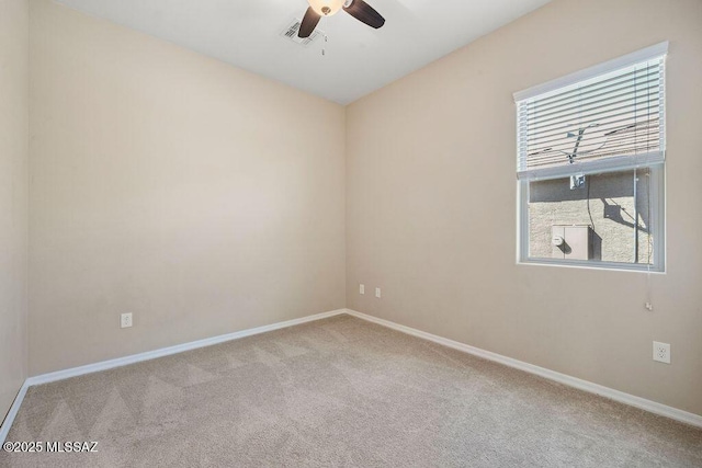 carpeted spare room featuring a ceiling fan, baseboards, and visible vents