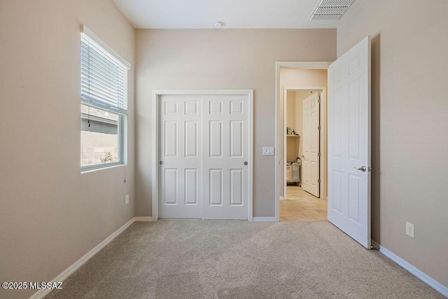 unfurnished bedroom with visible vents, carpet flooring, baseboards, and a closet