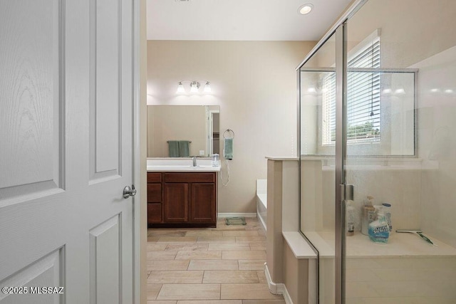 bathroom with vanity, a bath, wood finish floors, and a shower stall