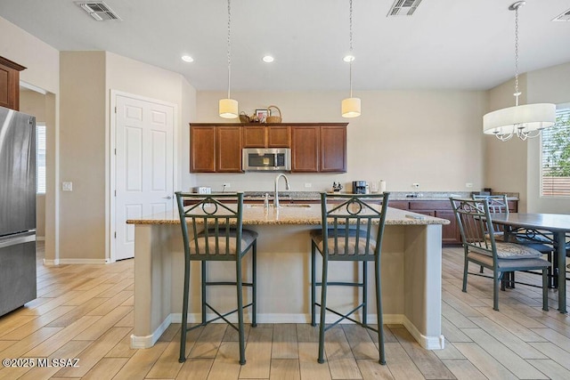 kitchen featuring stainless steel appliances, visible vents, and light wood-style floors