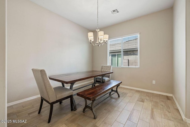 dining space featuring baseboards, a notable chandelier, light wood-style flooring, and visible vents