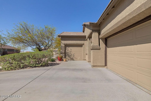 view of home's exterior featuring a garage, driveway, and stucco siding