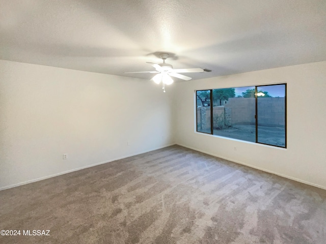 spare room featuring a textured ceiling, ceiling fan, and carpet