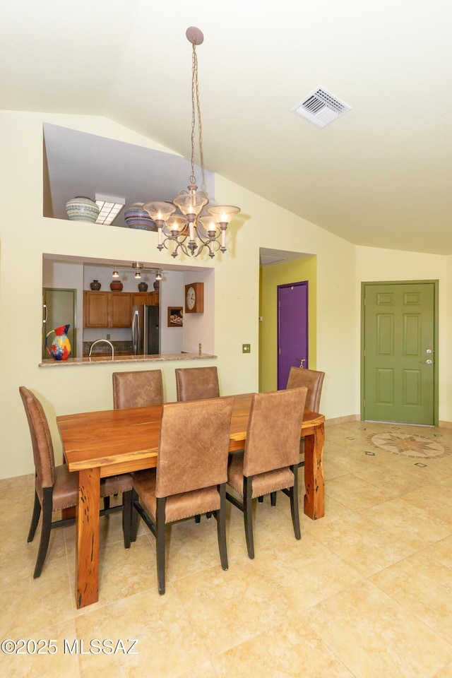 dining room featuring lofted ceiling, a chandelier, and tile patterned flooring