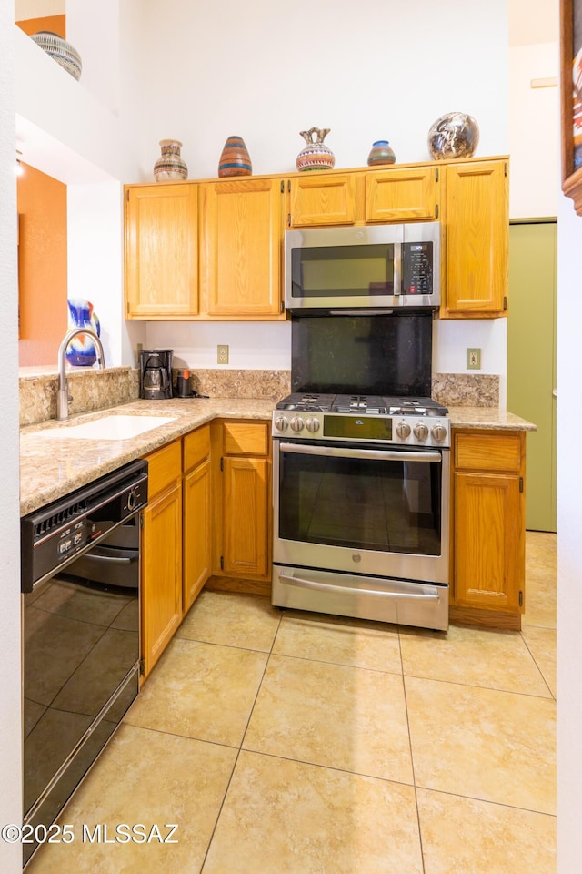 kitchen with light tile patterned flooring, appliances with stainless steel finishes, and sink