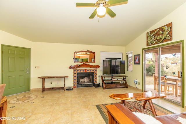 living room featuring a fireplace, ceiling fan, and vaulted ceiling