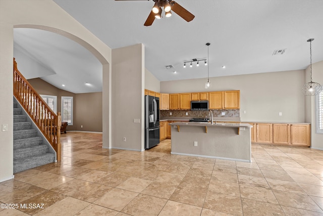 9797 E Holden Pl, Tucson, AZ 85748 - kitchen with stainless steel microwave, refrigerator with ice dispenser, lofted ceiling, decorative backsplash, and a ceiling fan
