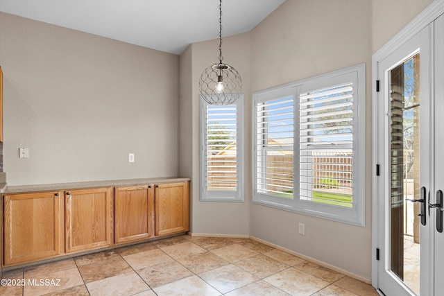 9797 E Holden Pl, Tucson, AZ 85748 - unfurnished dining area featuring lofted ceiling and baseboards