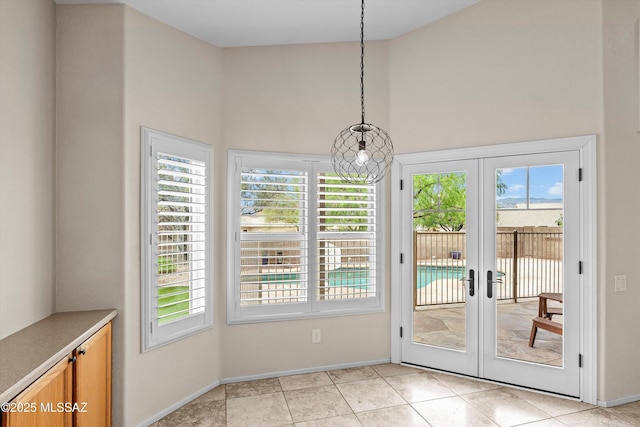 9797 E Holden Pl, Tucson, AZ 85748 - unfurnished dining area featuring a towering ceiling, healthy amount of natural light, french doors, and light tile patterned flooring
