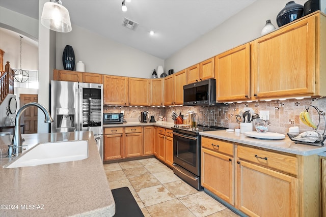 kitchen featuring decorative light fixtures, decorative backsplash, sink, stainless steel fridge, and range with electric cooktop