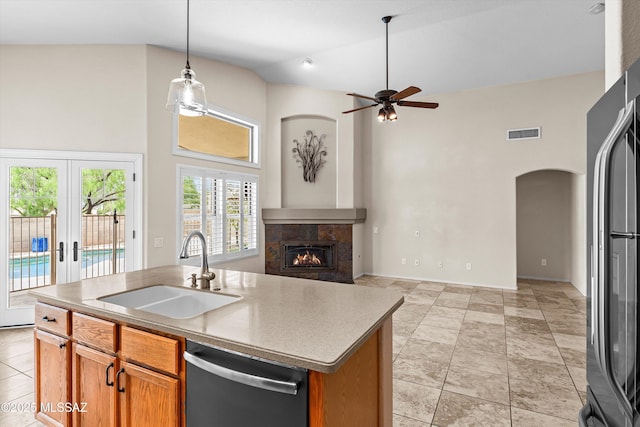 9797 E Holden Pl, Tucson, AZ 85748 - kitchen with stainless steel dishwasher, high vaulted ceiling, a ceiling fan, a tiled fireplace, and freestanding refrigerator