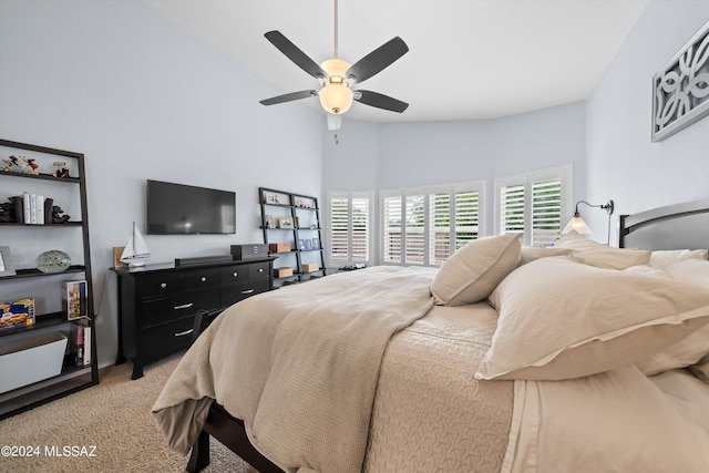 bedroom with ceiling fan, lofted ceiling, and carpet floors