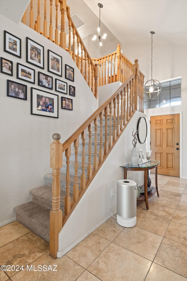 stairway with a chandelier and a towering ceiling