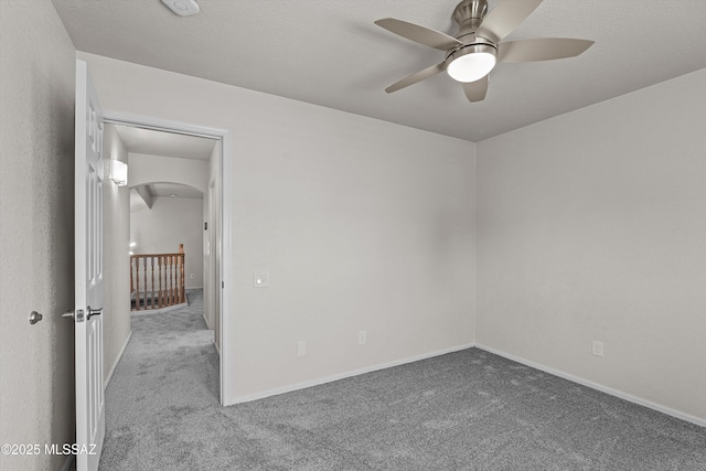 9797 E Holden Pl, Tucson, AZ 85748 - unfurnished room featuring carpet flooring, ceiling fan, arched walkways, and a smoke detector